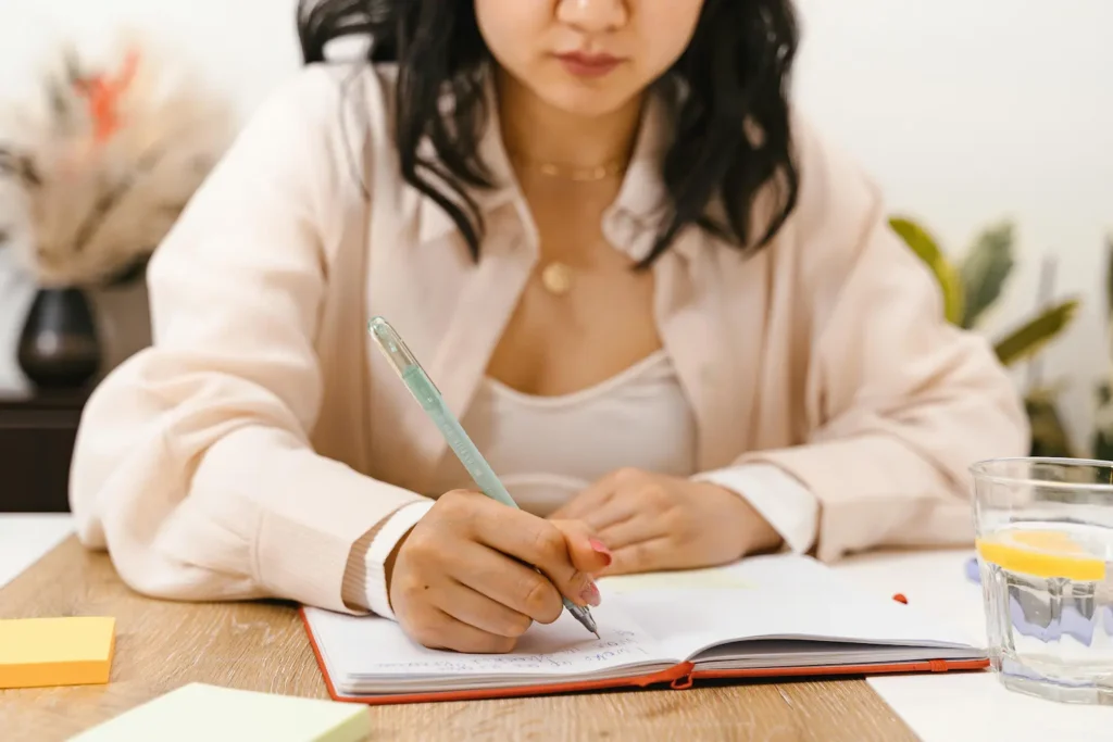 Herramientas básicas para escritores: cuaderno, taza y bolígrafo en escritorio preparado para la rutina de escritura